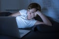 Young beautiful internet addicted sleepless and tired woman working on laptop in bed late at night Royalty Free Stock Photo