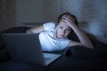 Young beautiful internet addicted sleepless and tired woman working on laptop in bed late at night Royalty Free Stock Photo