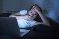 Young beautiful internet addicted sleepless and tired woman working on laptop in bed late at night Royalty Free Stock Photo