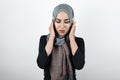 Young beautiful irritated Muslim woman wearing turban hijab, headscarf looking angry with her hands closing ears