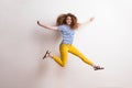 Young beautiful joyful woman with long curly hair in studio, jumping. Royalty Free Stock Photo