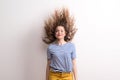 Young beautiful joyful woman with long curly hair in studio, jumping. Royalty Free Stock Photo