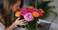 Young beautiful lady enjoys aroma of colorful bouquet of rose flowers. Romantic Royalty Free Stock Photo