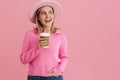 Young beautiful lady in pink hat and sweater with coffee