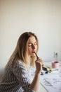 Young beautiful lady sitting at white desk and think about calligraphy Royalty Free Stock Photo