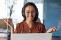 Young beautiful latin american woman with headset phone talking on video call using laptop, business woman inside office Royalty Free Stock Photo