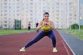 Young beautiful Latin big brunette woman is engaged in fitness outdworth. Stretching before running on the stadium Royalty Free Stock Photo