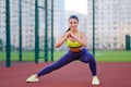 Young beautiful Latin big brunette woman is engaged in fitness outdworth. Stretching before running on the stadium Royalty Free Stock Photo