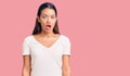 Young beautiful latin girl wearing casual white t shirt scared and amazed with open mouth for surprise, disbelief face Royalty Free Stock Photo