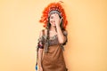 Young beautiful latin girl wearing indian costume covering one eye with hand, confident smile on face and surprise emotion Royalty Free Stock Photo