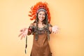 Young beautiful latin girl wearing indian costume smiling cheerful offering hands giving assistance and acceptance Royalty Free Stock Photo