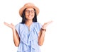 Young beautiful latin girl wearing summer hat and glasses celebrating mad and crazy for success with arms raised and closed eyes Royalty Free Stock Photo