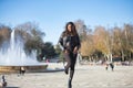 Young, beautiful, Latin and South American woman with leather jacket and top, jeans and platform shoes, hands in pockets posing Royalty Free Stock Photo