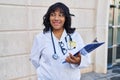 Young beautiful latin woman doctor smiling confident holding clipboard at hospital Royalty Free Stock Photo