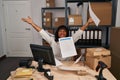 Young beautiful latin woman ecommerce business worker throwing documents at office Royalty Free Stock Photo