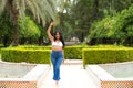 Young and beautiful Latin woman from South America walks among the trees and vegetation of the park. The woman is smiling and