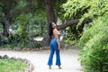 Young and beautiful Latin woman from South America walks among the trees and vegetation of the park. The woman is smiling and