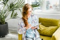 Young beautiful long haired college student girl in casual shirt with notebook,organizer pen sitting on yellow chair Royalty Free Stock Photo