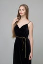 Young beautiful long-haired girl stands in black dress Royalty Free Stock Photo
