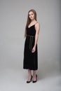 Young beautiful long-haired girl stands in long black dress Royalty Free Stock Photo