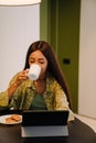 Young beautiful long-haired woman drinking coffee with cookies Royalty Free Stock Photo