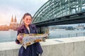 Young beautiful looking a map and view of river with beautiful Cologne Cathedral in Germany