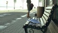 Young, beautiful, lovely woman sitting on bench in park, in hands of her notebook. She is wearing a coat. She makes Royalty Free Stock Photo