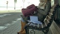 Young, beautiful, lovely woman sitting on bench in park, in hands of her notebook. She is wearing a coat. She makes Royalty Free Stock Photo