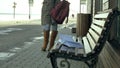 Young, beautiful, lovely woman sitting on bench in park, in hands of her notebook. She is wearing a coat. She makes Royalty Free Stock Photo