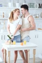 Young beautiful loving couple making fresh orange juice and having fun in the kitchen Royalty Free Stock Photo