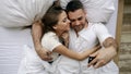 Young beautiful and loving couple take selfie picture on smartphone camera lying in bed at the morning Royalty Free Stock Photo