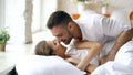 Young beautiful and loving couple wake up at the morning. Attractive man kiss and hug his wife in bed Royalty Free Stock Photo