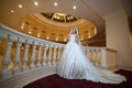 Young beautiful luxurious woman in wedding dress posing in luxurious interior. Bride with huge wedding dress in majestic manor Royalty Free Stock Photo