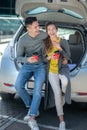 Young beautiful man and woman drinking coffee near a car Royalty Free Stock Photo
