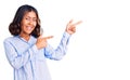 Young beautiful mixed race woman wearing casual business shirt smiling and looking at the camera pointing with two hands and Royalty Free Stock Photo