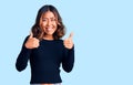 Young beautiful mixed race woman wearing casual clothes success sign doing positive gesture with hand, thumbs up smiling and happy Royalty Free Stock Photo