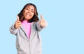 Young beautiful mixed race woman wearing casual sporty clothes approving doing positive gesture with hand, thumbs up smiling and Royalty Free Stock Photo