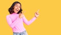 Young beautiful mixed race woman wearing pink shirt smiling and looking at the camera pointing with two hands and fingers to the Royalty Free Stock Photo