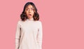 Young beautiful mixed race woman wearing winter turtleneck sweater afraid and shocked with surprise and amazed expression, fear Royalty Free Stock Photo
