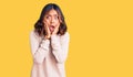 Young beautiful mixed race woman wearing winter turtleneck sweater afraid and shocked, surprise and amazed expression with hands Royalty Free Stock Photo