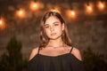 Young beautiful model. brunette looks into the camera. Teenage girl in a black dress in the evening Royalty Free Stock Photo