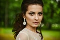 Young beautiful model woman with wedding hairstyle, with expensive earrings and with bright makeup Royalty Free Stock Photo