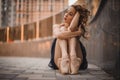 Young beautiful modern style ballet dancer sitting on the ground in black dress . selective focus. Royalty Free Stock Photo