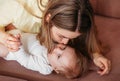 Young beautiful mom kisses her newborn daughter on the bed Royalty Free Stock Photo