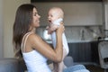 young beautiful mom is sitting on the couch. Holds a newborn baby in her arms. play with your child.