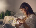 Young beautiful mother, breastfeeding her newborn baby boy at ni Royalty Free Stock Photo