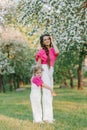 A young beautiful mother is happy and holding her daughter in her arms, they are having fun in the spring park Royalty Free Stock Photo