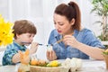 Young beautiful mother and her child painting together eggs for Royalty Free Stock Photo