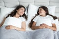 Young beautiful mother and her cute teen daughter just woke up together in bed Royalty Free Stock Photo