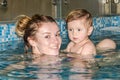 Young beautiful mother and her daughter happy family, play, fool around, and swimming in a pool of blue water, with positive emoti Royalty Free Stock Photo